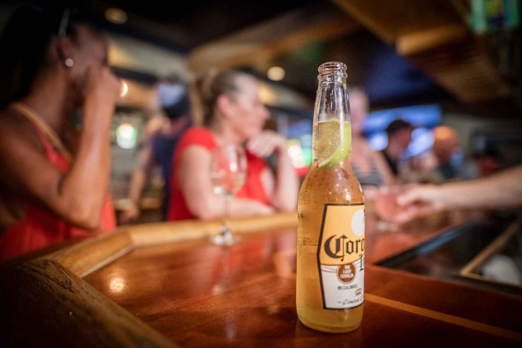 A close-up of a bottle of Corona beer placed on top of a bar.